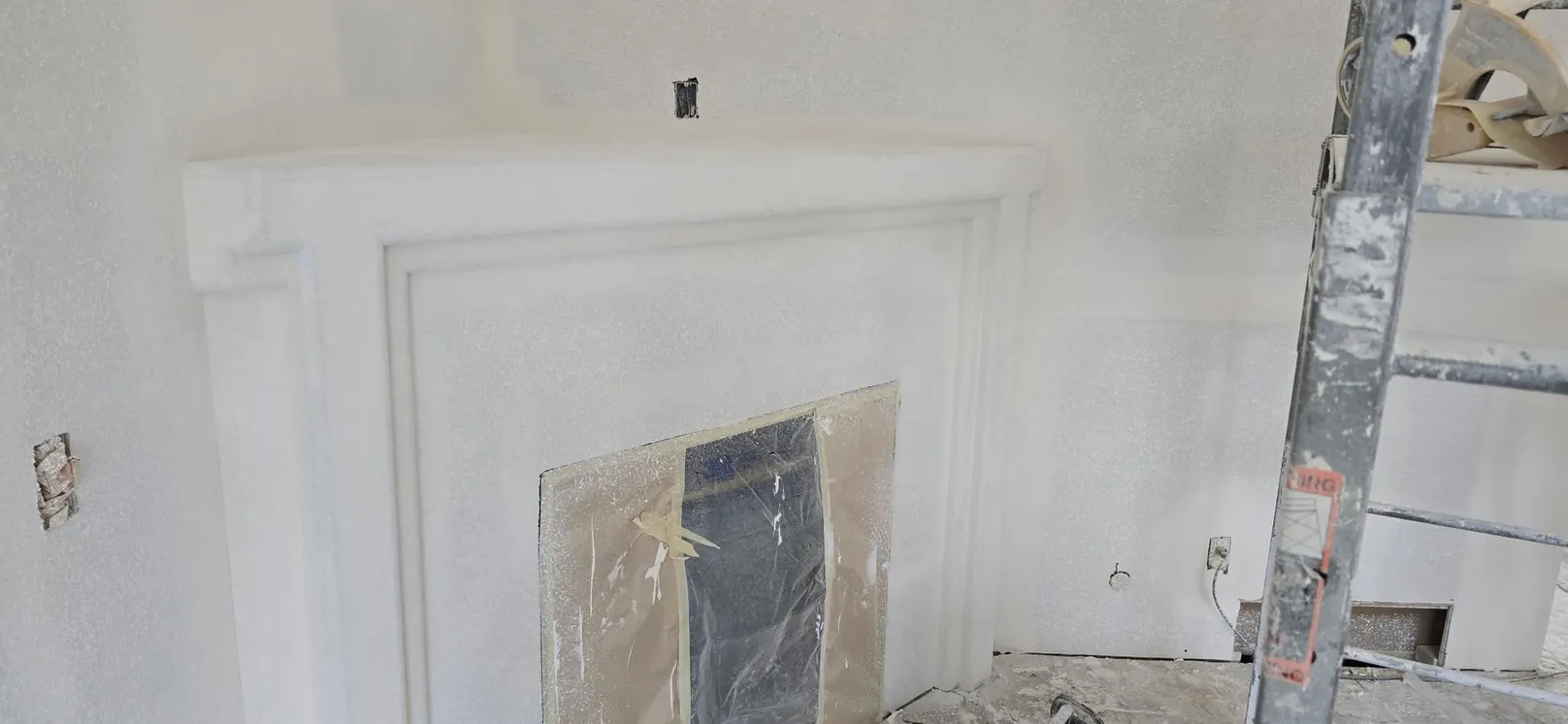 Fireplace surround and adjoining walls finished with orange peel drywall texture